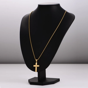3D textured gold cross pendant necklace displayed on a black mannequin stand