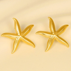 Detailed close-up of 18k gold starfish stud earrings with intricate radial textures