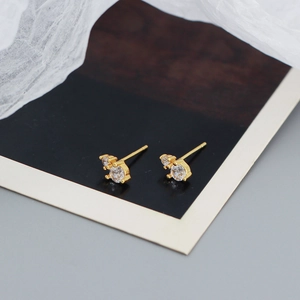 Macro shot of gold silver earrings featuring double clear round cubic zirconia studs