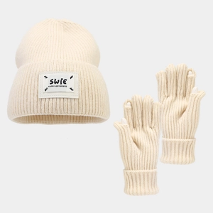Detail of cream white knitted hat and fingerless gloves with a leather brand label