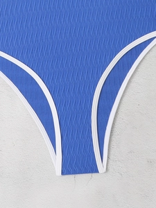 Detailed close-up of royal blue swimsuit fabric with white trim and wavy ribbed texture