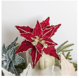 Macro detail of red velvet Christmas flower with gold glitter and pine needle accents