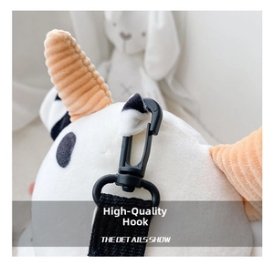 Detail showing the durable black plastic hook and strap on the cow plush crossbody bag