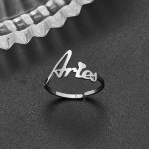Macro shot of silver stainless steel adjustable Aries constellation ring on grey background