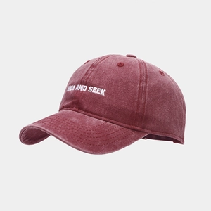 Detail of burgundy washed cotton baseball cap with white HIDE AND SEEK embroidery