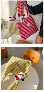 Close-up of plush striped tote bag with soft fabric detail and cute dog charm decoration
