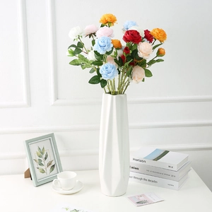 Vibrant multi-colored faux peonies in a modern white geometric ceramic vase for decor
