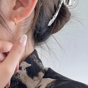 Minimalist 925 sterling silver gold hoop earrings with textured curved design on model