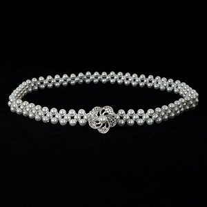 Detailed view of elegant double-row pearl waist chain with a silver flower buckle clasp