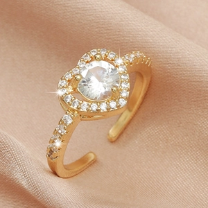 Macro detail of gold-plated heart ring featuring a large zircon and micro-pave setting