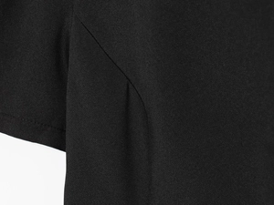 Vue macro du tissu tissé noir montrant des coutures précises et une texture mate détaillée