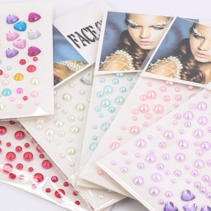 Detailed view of colorful heart and round pearl face jewels set for DIY makeup art