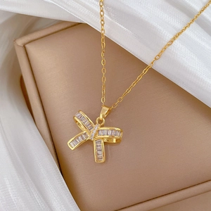 Elegant gold butterfly necklace with zircon stones on white silk luxury background