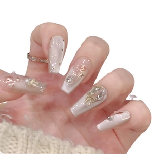 Handmade almond nails with gold roses, pearls, and rhinestones in nude finish