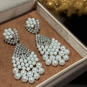 Close-up of vintage pearl tassel earrings with rhinestones in a luxury jewelry box