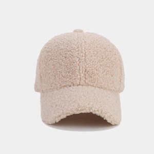 Close-up detail of thick beige lamb wool fabric and soft texture on the baseball cap