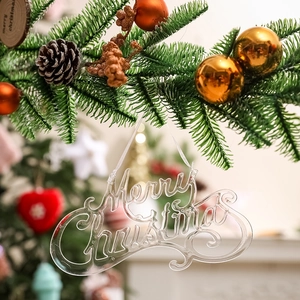 Hanging transparent acrylic Merry Christmas sign on tree with festive decor and pine cones