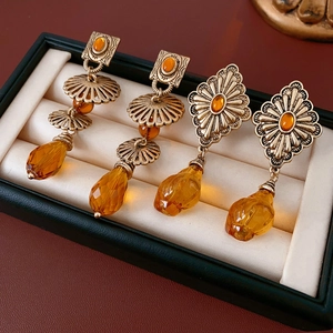 Macro shot of vintage bronze earrings with amber teardrop pendants in a jewelry box