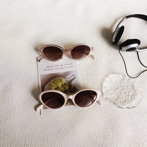 Fashionable cat-eye sunglasses with beige and nude frames and brown gradient lenses