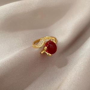 Elegant gold open ring featuring a large red round gemstone and micro-pave crystals