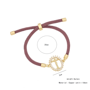 Dettaglio del bracciale regolabile in rame viola con ciondolo a croce e micro cristalli