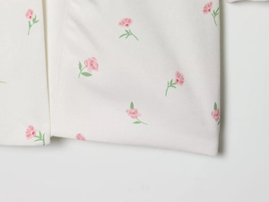 Detaillierte Makroansicht des weißen gewebten Stoffes mit rosa und grünen Blumen