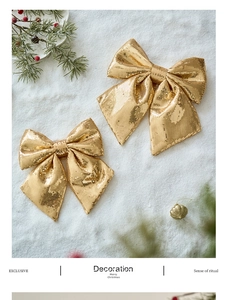 Detail of glittery gold Christmas bows on a snowy background with pine needles