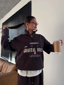 Sweat à demi-zip marron surdimensionné avec imprimé vintage porté par un mannequin en intérieur