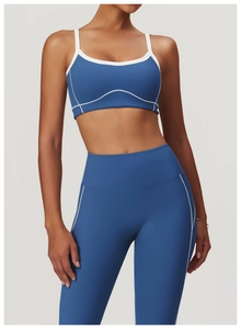 Détail d'un ensemble de yoga bleu roi avec coutures blanches sur le legging et la brassière