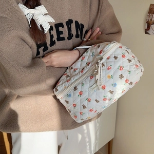Quilted cotton makeup bag with cute bear and floral print held by a model