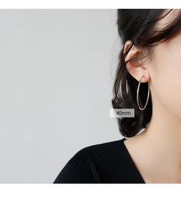 Detailed view of 40mm minimalist S925 sterling silver hoop earrings worn by a model