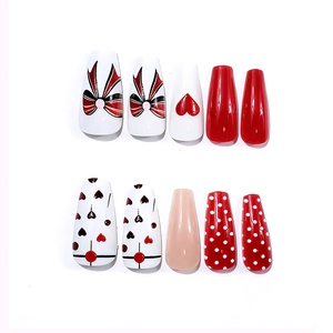 Unghie finte lunghe a ballerina con cuori rossi, pois e dolci motivi a fiocco