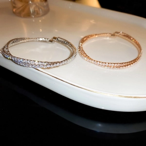 Close-up of silver and rose gold zircon paved bangles on a luxury ceramic tray