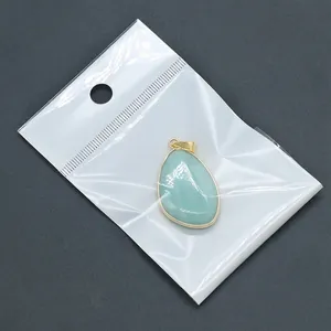 Teardrop light blue natural stone pendant with gold plated edges in transparent packaging