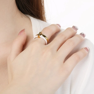Close-up of a double-band gold titanium and white ceramic ring with zircon detailing