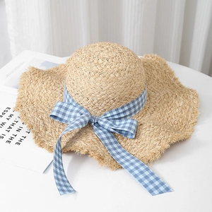 Wide brim raffia straw sun hat with blue gingham ribbon and frayed edges for beach