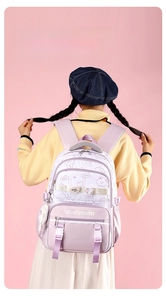 Detail of purple student backpack with cartoon bear and OUR YOUTH text on front pockets