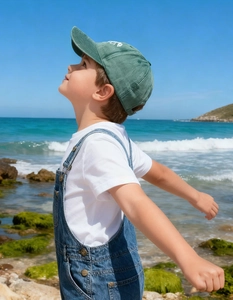 Detailed view of kids' dinosaur bone embroidery on a washed vintage baseball cap