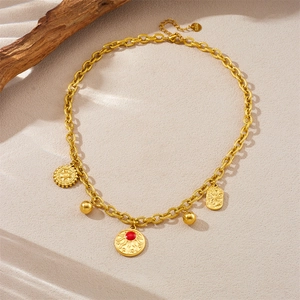 Detail of gold-plated stainless steel chain with sun pendant and red gemstone charm