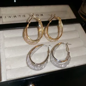Chic oval hollow hoop earrings set in gold and silver finish with glitter lining