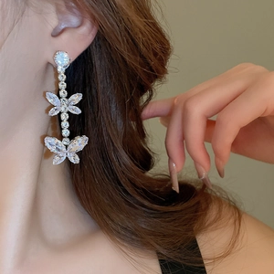 Detailed close-up of a silver butterfly tassel earring with sparkling zircon crystals