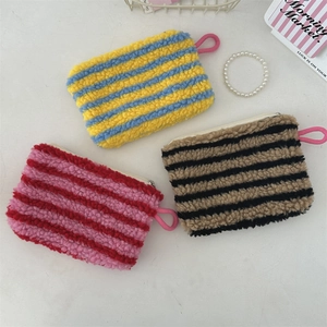 Flat lay of colorful striped plush mini pouches with soft fabric and zippers