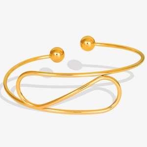 Detail shot of a minimalist 18K gold plated 304 stainless steel open bangle with bead ends