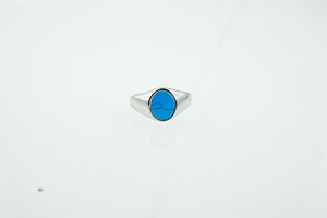 Detailed macro view of an oval blue turquoise gemstone set in a polished silver ring