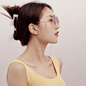 Golden eyewear chain with colorful floral charms and sunglasses on fashion model