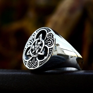 Polished silver Viking Celtic knot stainless steel ring for men on textured surface