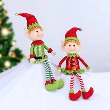 Detail view of two plush Christmas elf dolls with sequins and striped legs in red and green