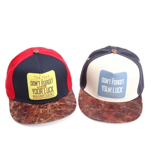 Detail of hip hop hats with marble texture brims and embroidered motivational patches