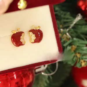 Detail of red apple stud earrings with crystals in a festive Christmas gift box