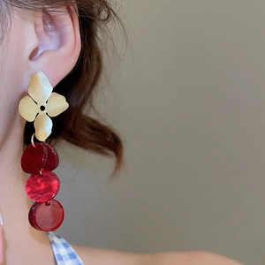 Detailed close-up of retro floral stud with layered dark red acrylic round pendants